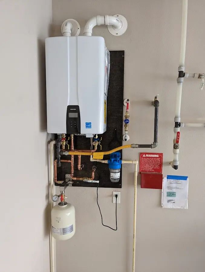 Professional plumber installing copper piping in a Justin home